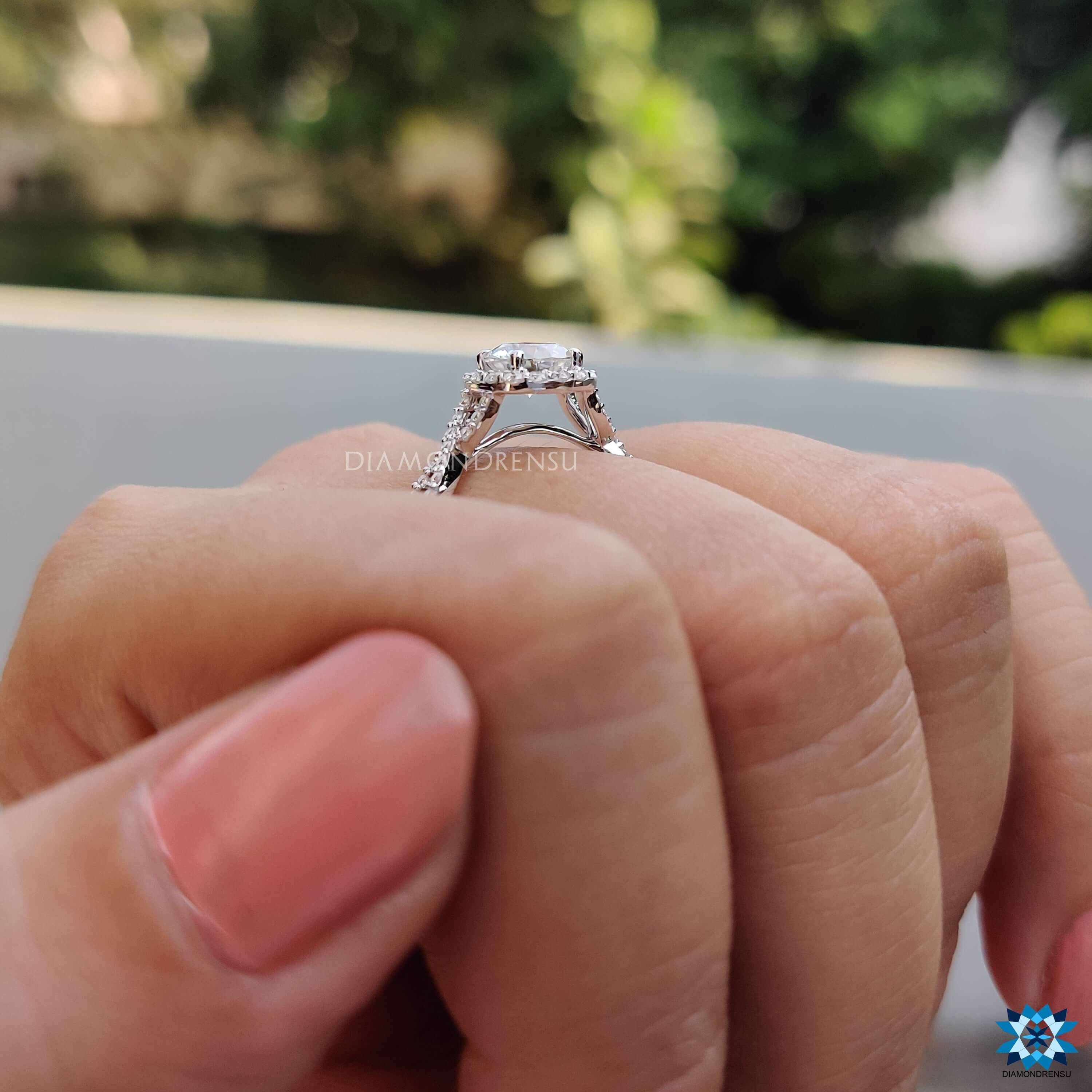 Round cut moissanite engagement ring with halo and pave.