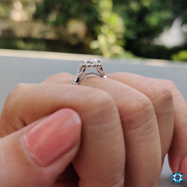 Round cut moissanite engagement ring with halo and pave.