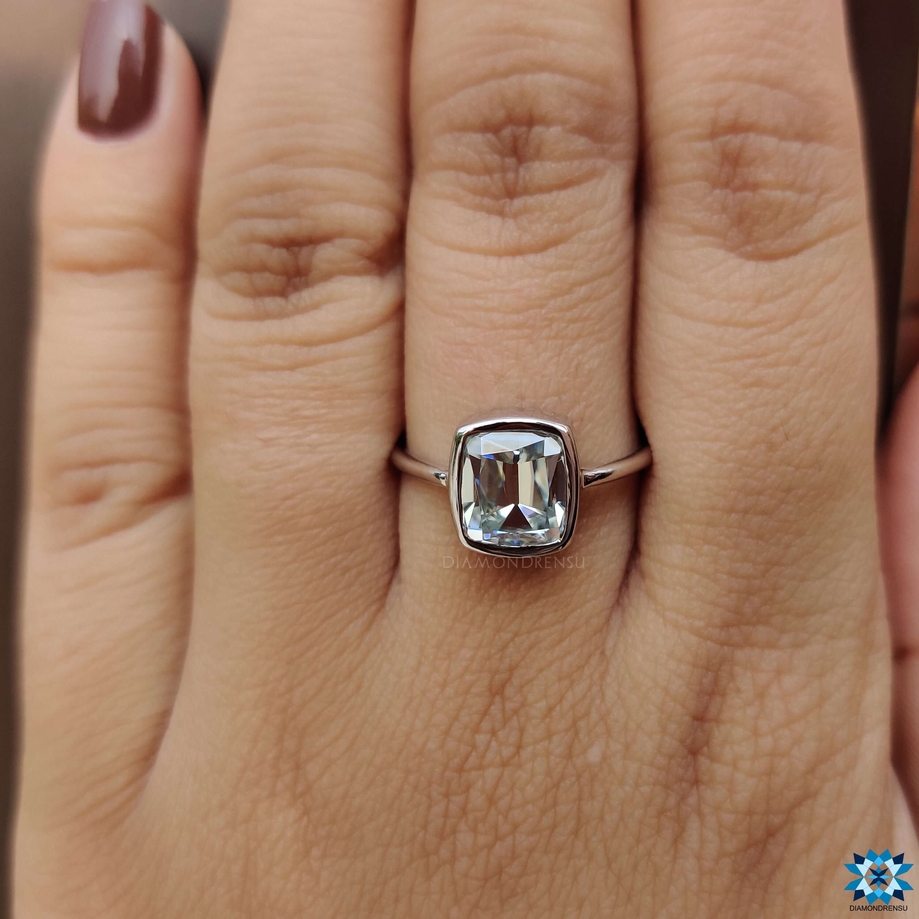 Cushion bezel set engagement ring with vintage-inspired cut.