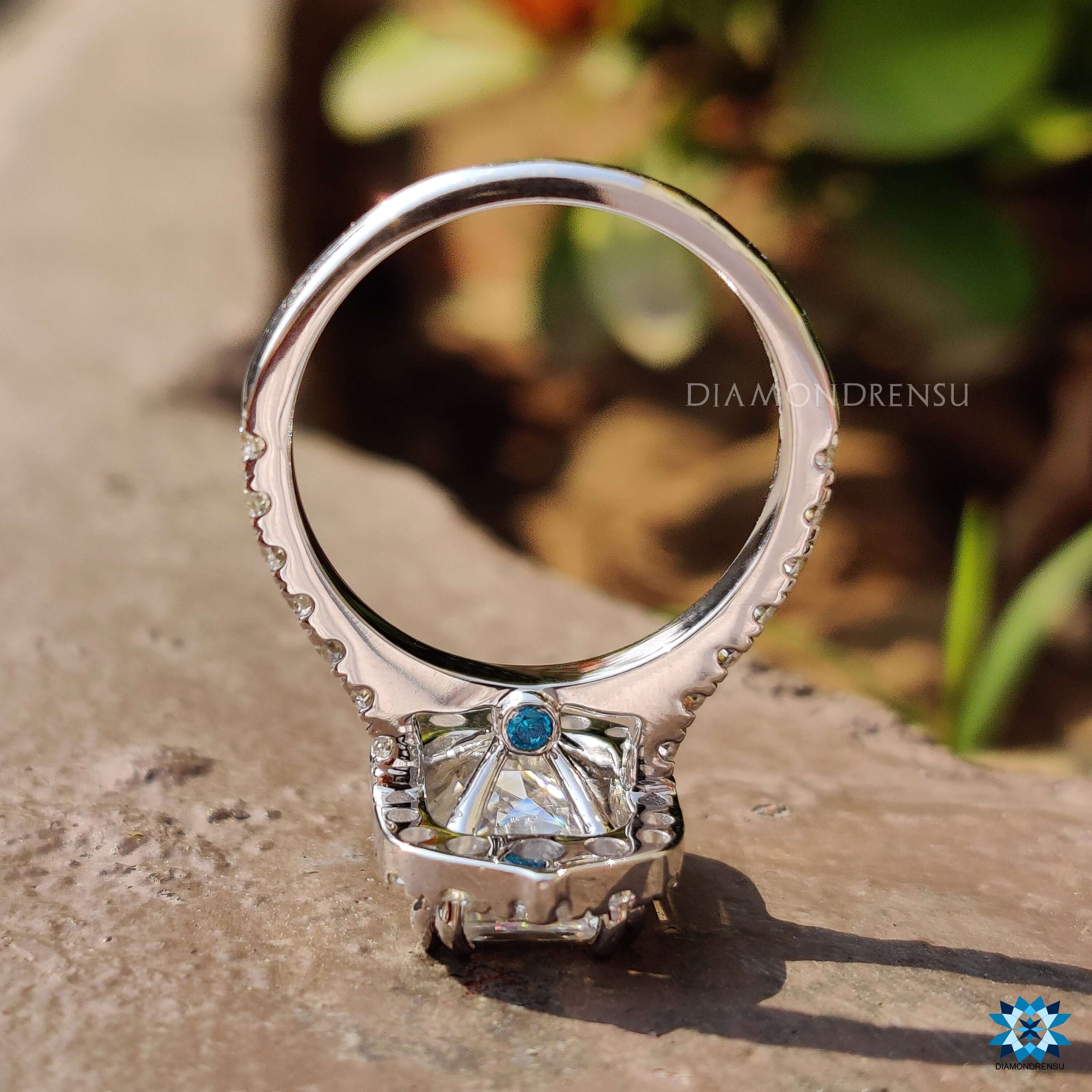 White gold engagement ring with blue moissanite and peekaboo detail.