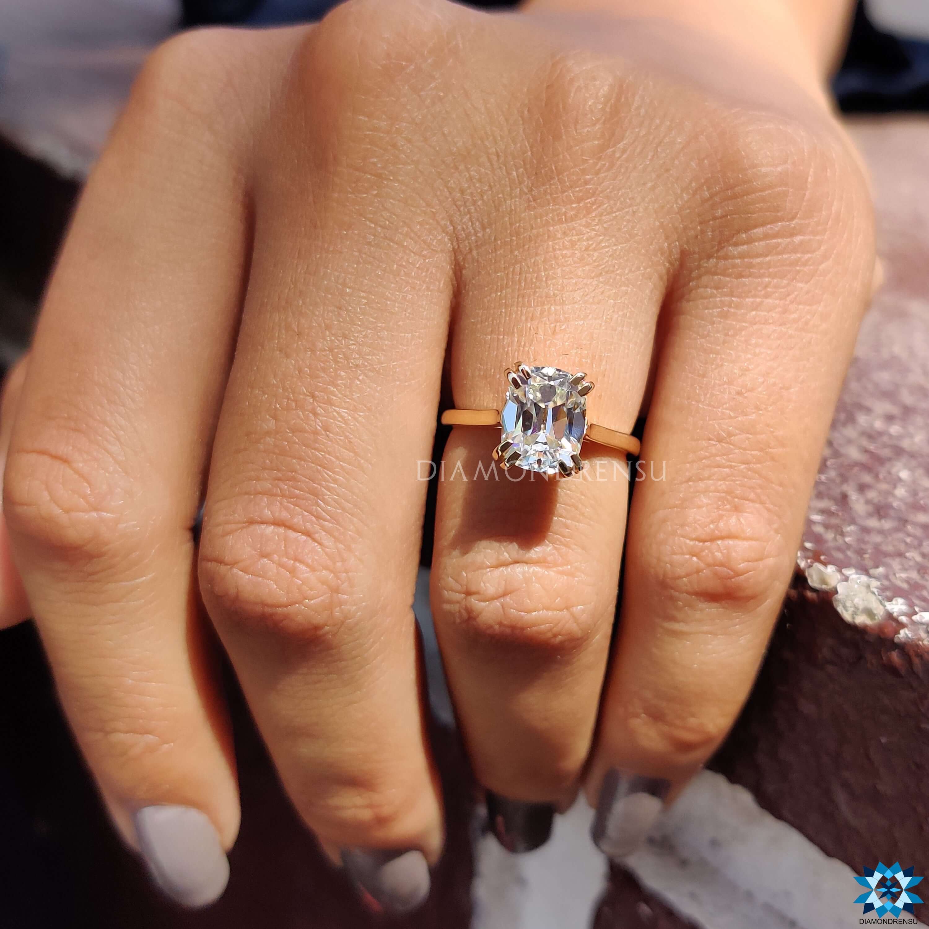Yellow gold solitaire engagement ring with cushion moissanite.