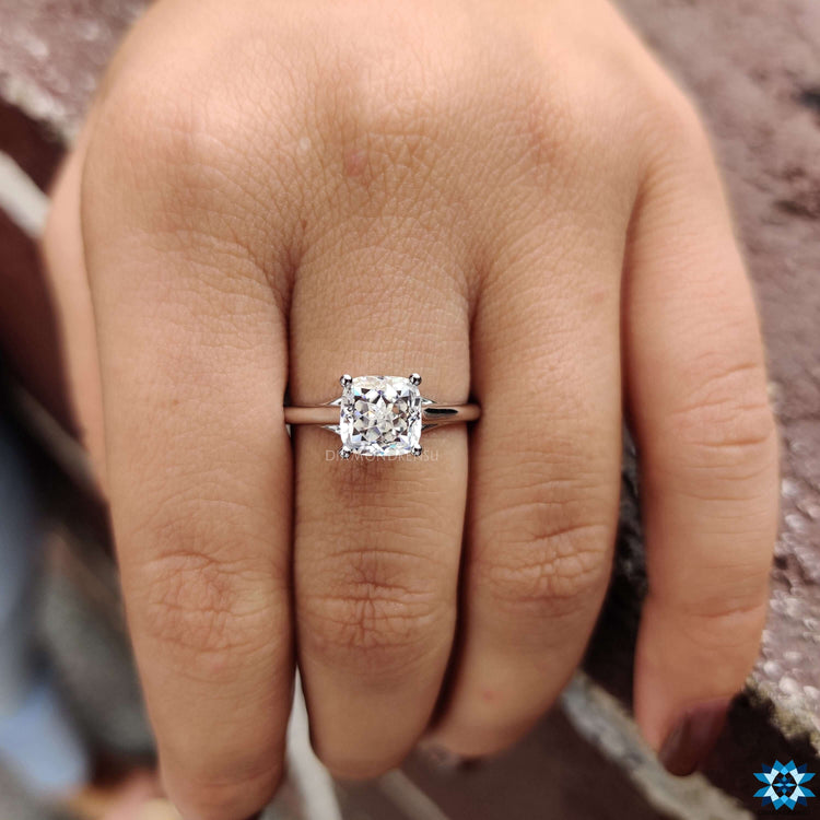 White gold engagement ring featuring a Cushion Rensu moissanite center stone.