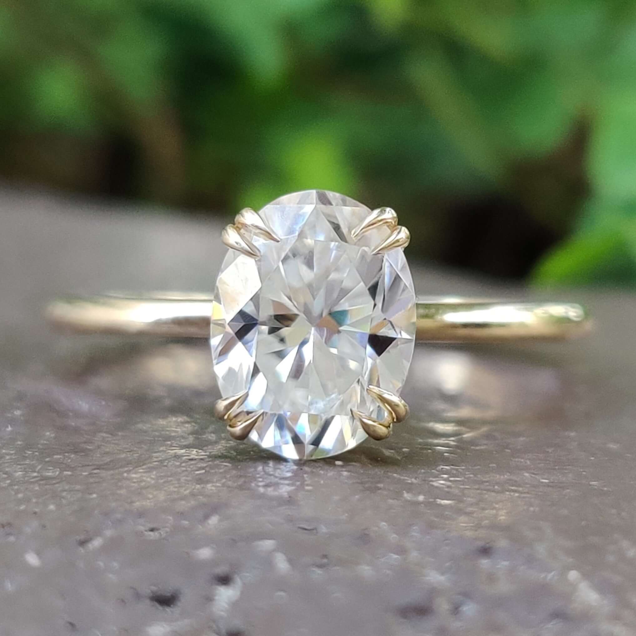 Oval cut moissanite solitaire engagement ring in yellow gold.