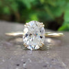 Oval cut moissanite solitaire engagement ring in yellow gold.