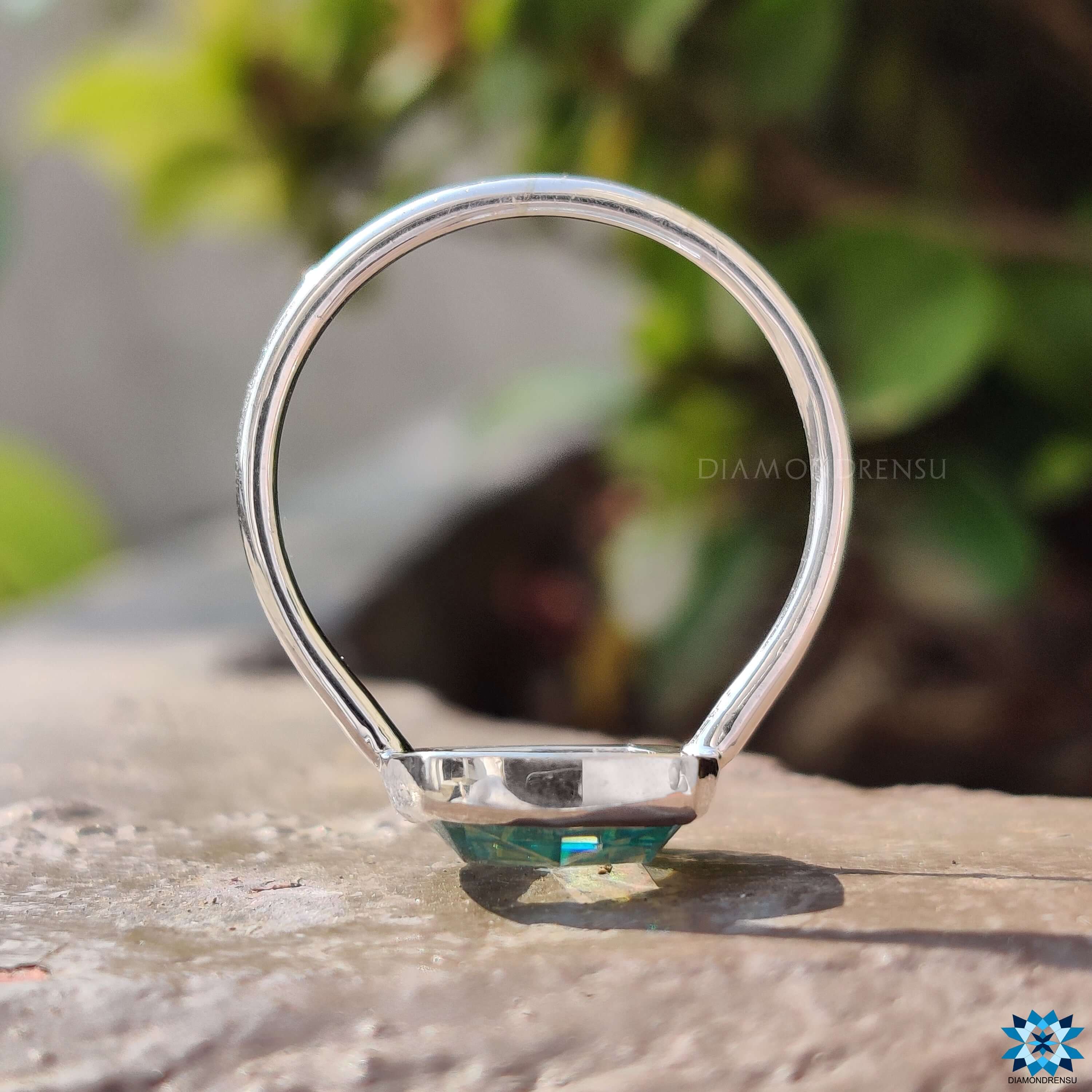 Simple bezel setting ring featuring a cushion cut cyan blue stone.