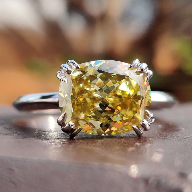 Cushion cut hidden halo engagement ring with yellow moissanite.