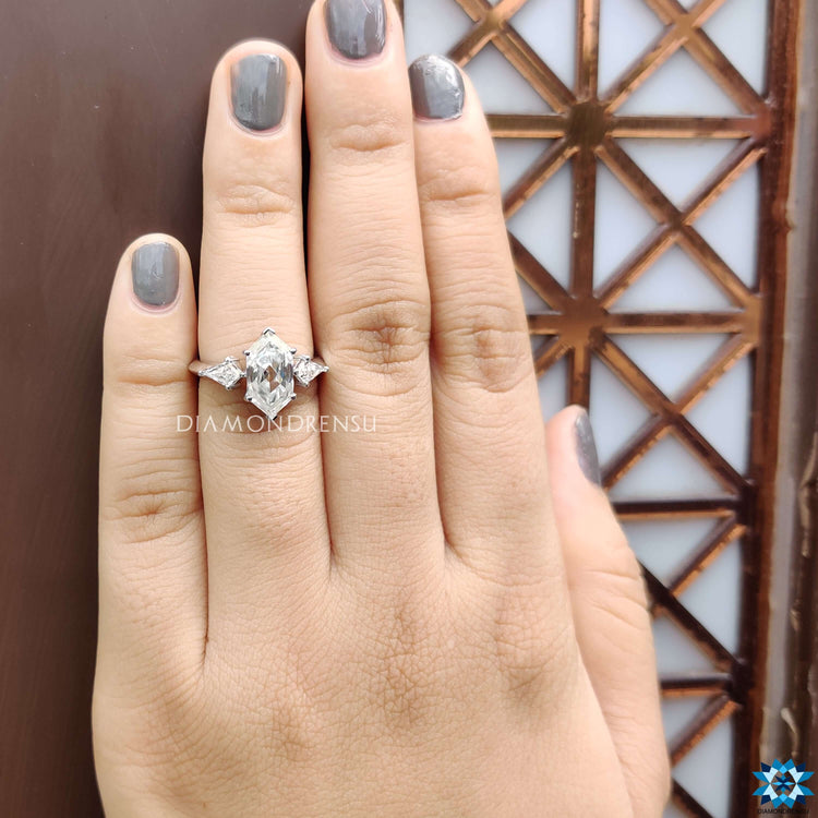 Three stone moissanite ring featuring a unique elongated hexagon centre in prong setting.
