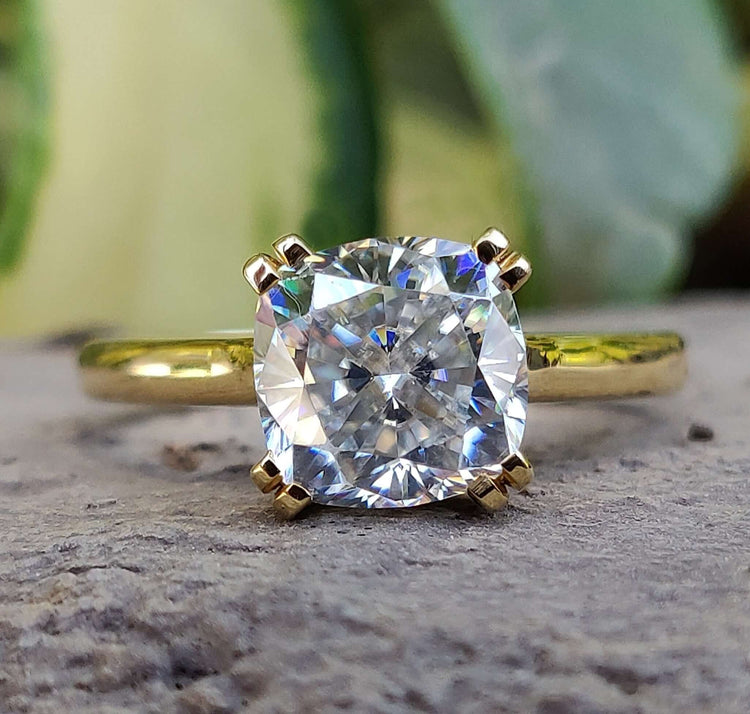 Cushion cut moissanite engagement ring with Double Prong Setting in yellow gold.