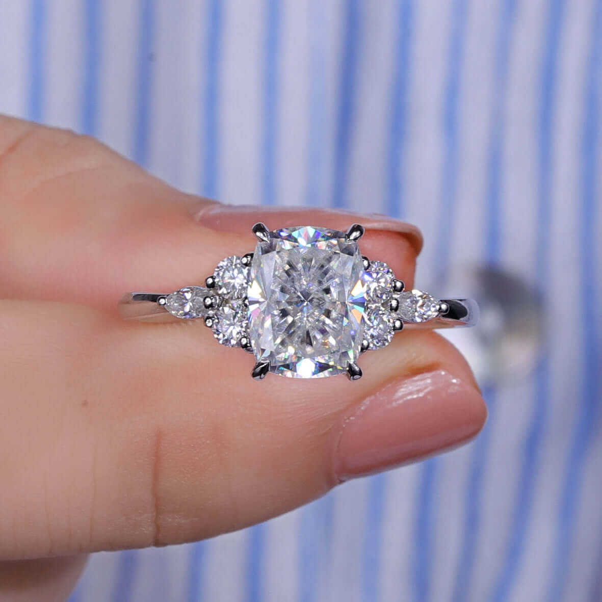 Cushion cut moissanite ring featuring marquise and round side stones.