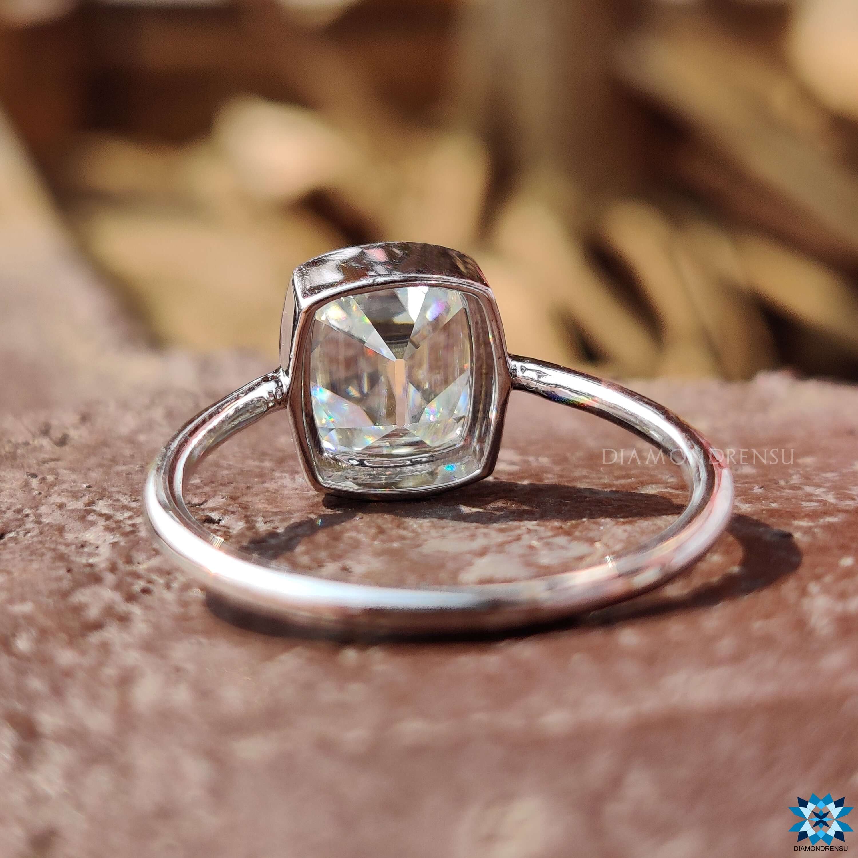 Custom cushion cut engagement ring in bezel mount.
