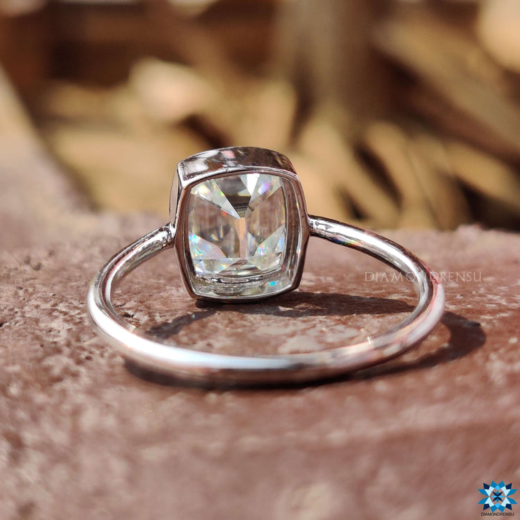 Custom cushion cut engagement ring in bezel mount.
