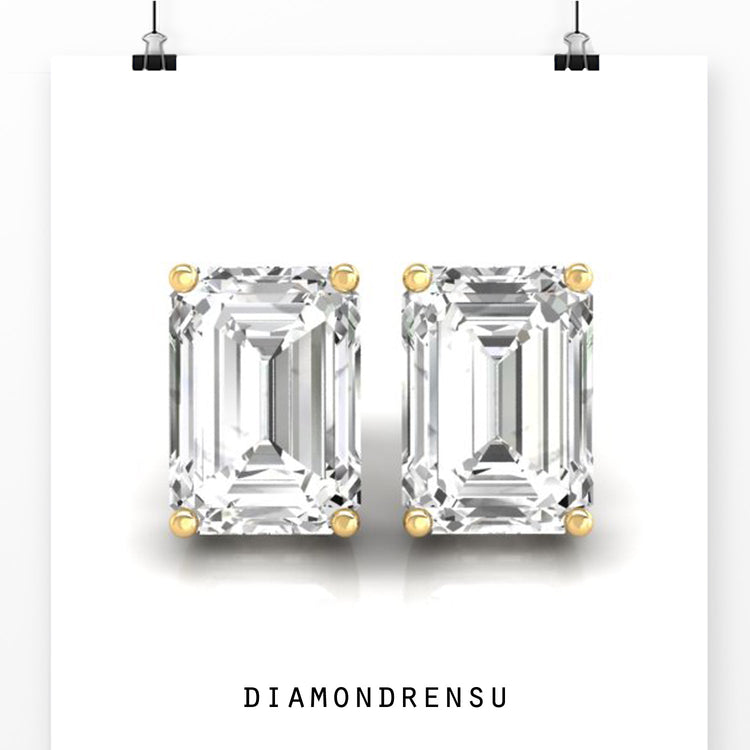 Gold diamond earrings with emerald cut stones and prong setting.