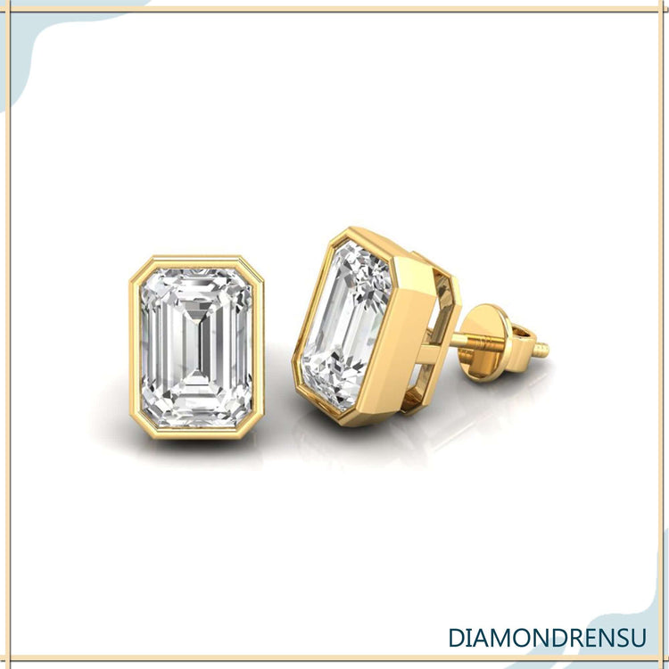 UK diamond earrings featuring emerald step cut stones in bezel mount.