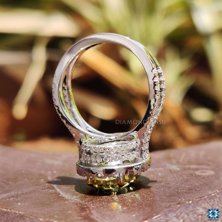 Four claw prong setting holding oval canary yellow moissanite.