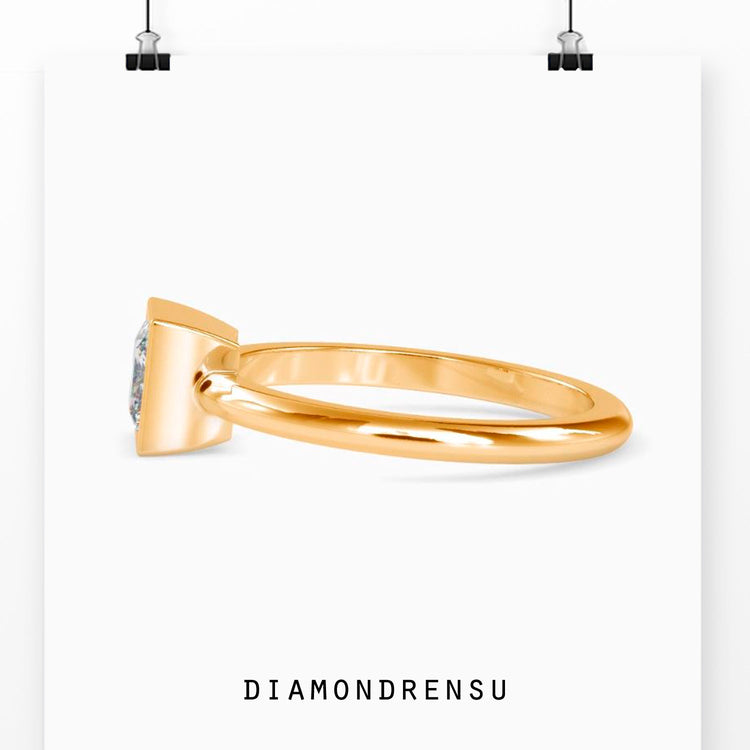 UK engagement ring with bezel set solitaire in yellow gold.