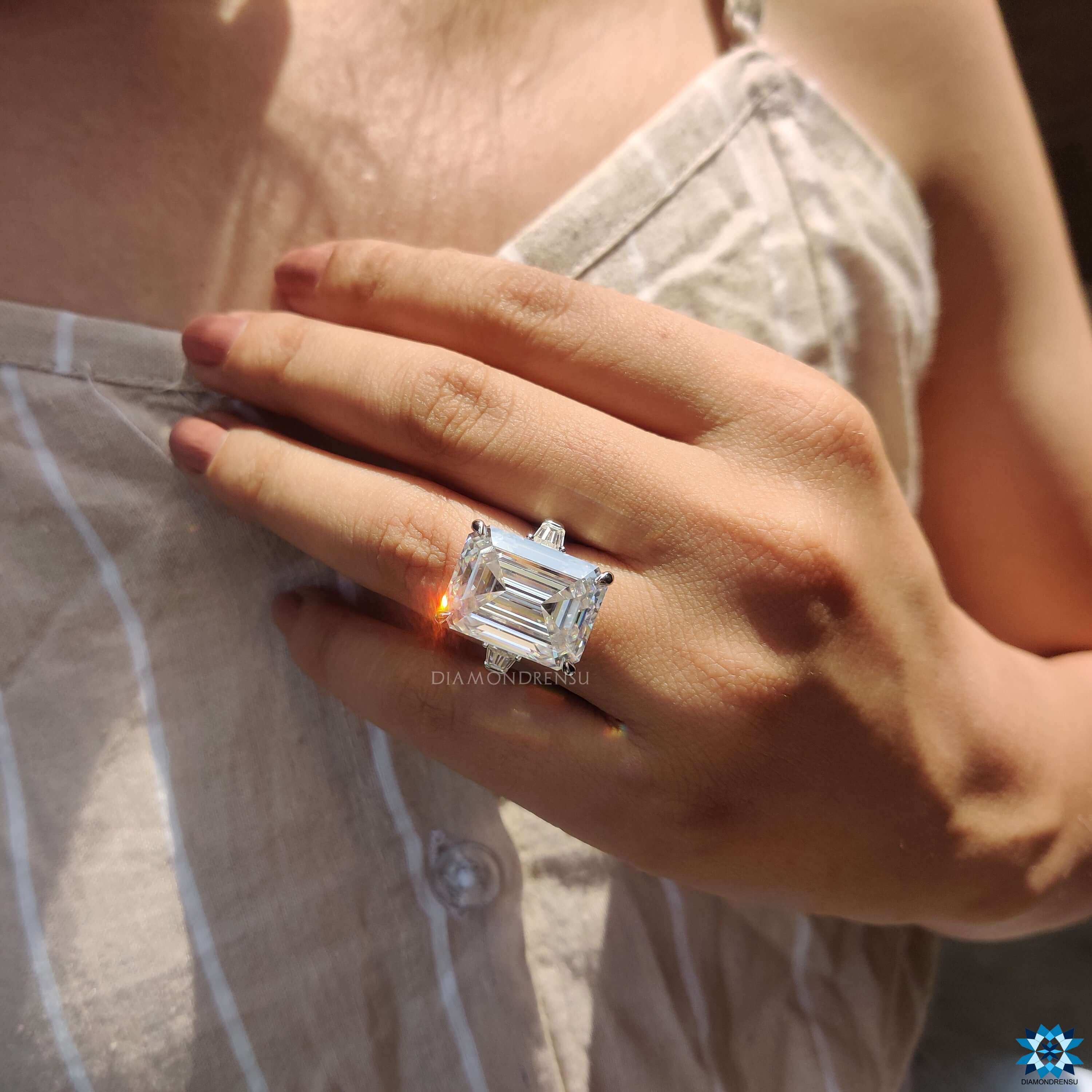 Emerald cut moissanite ring with tapered baguette sides.