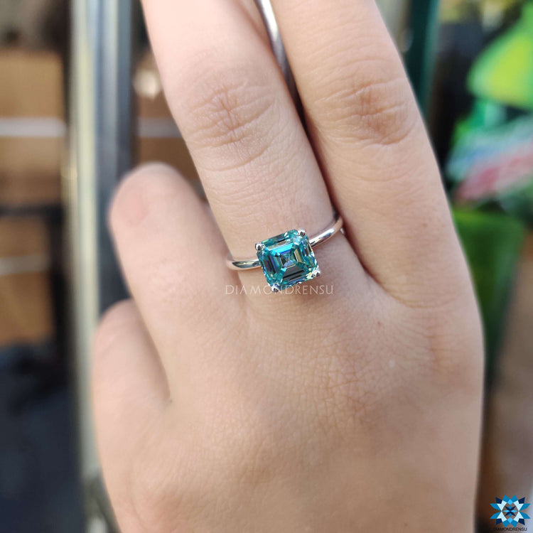 Blue moissanite solitaire engagement ring in prong setting.