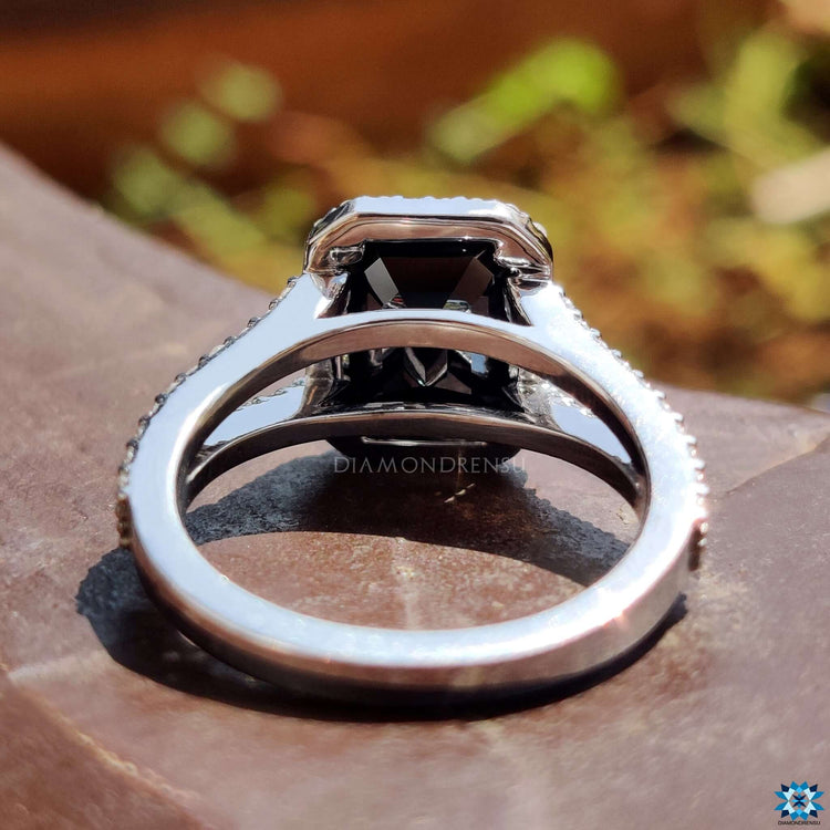 Unique engagement ring with black emerald center and round halo stones.