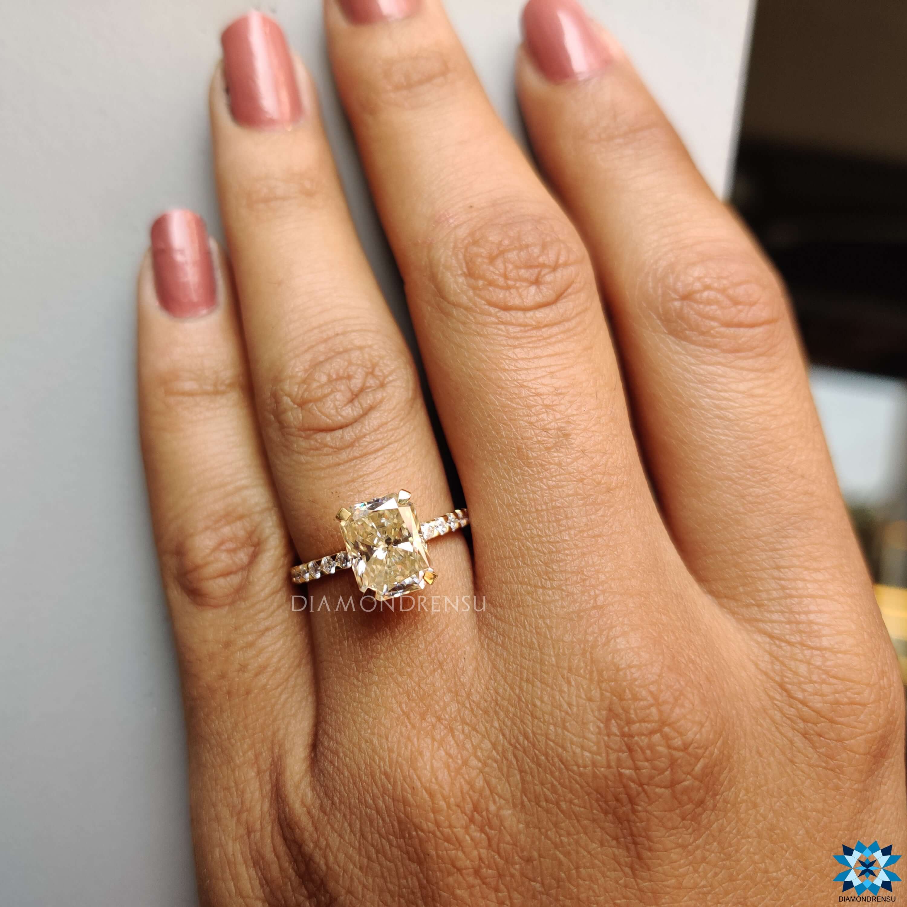 Radiant cut moissanite ring in light yellow gold.