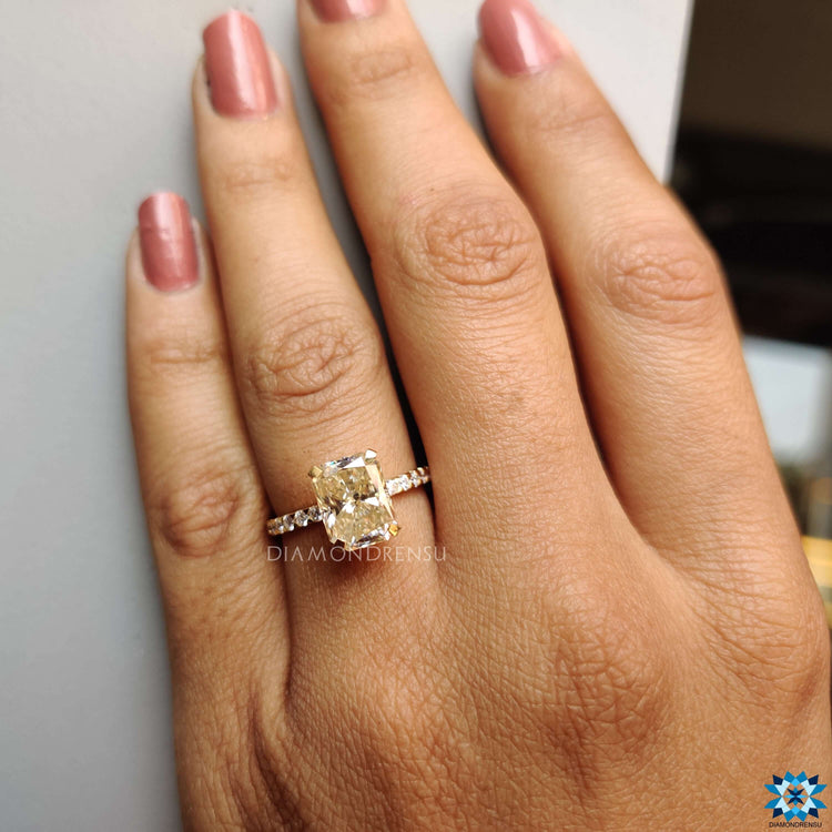 Radiant cut moissanite ring in light yellow gold.