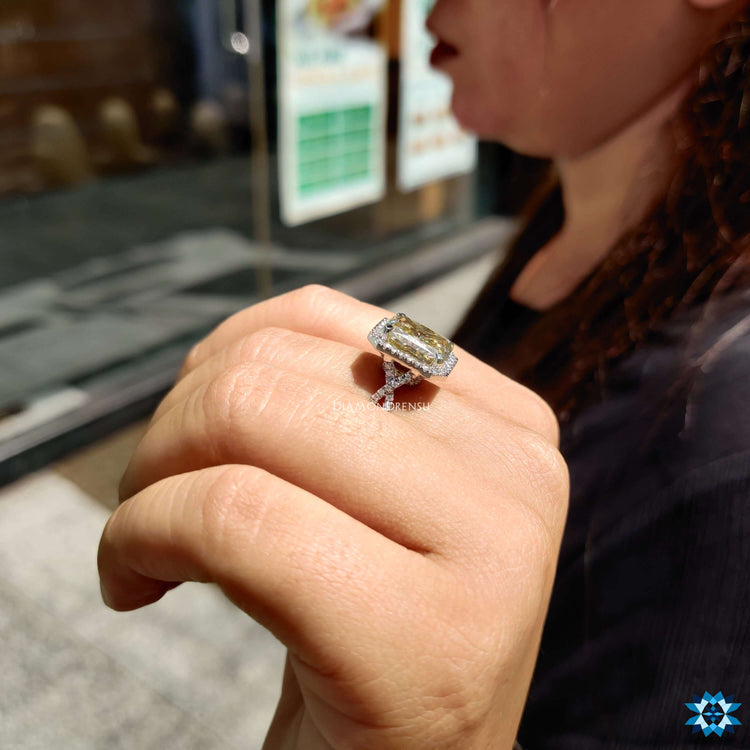 Radiant cut ring with round halo and twisted band.