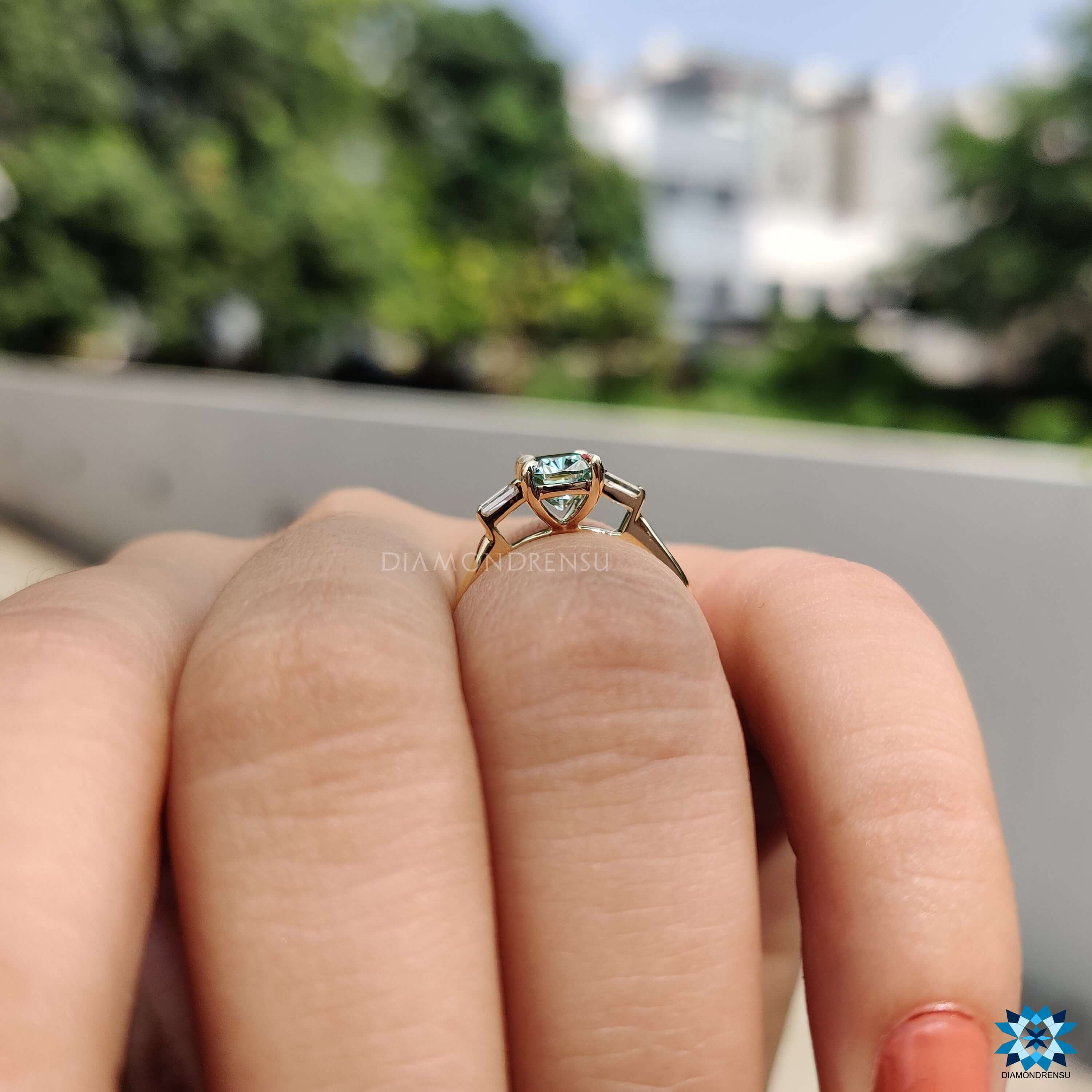Blue moissanite engagement ring with 4 claw prong setting.