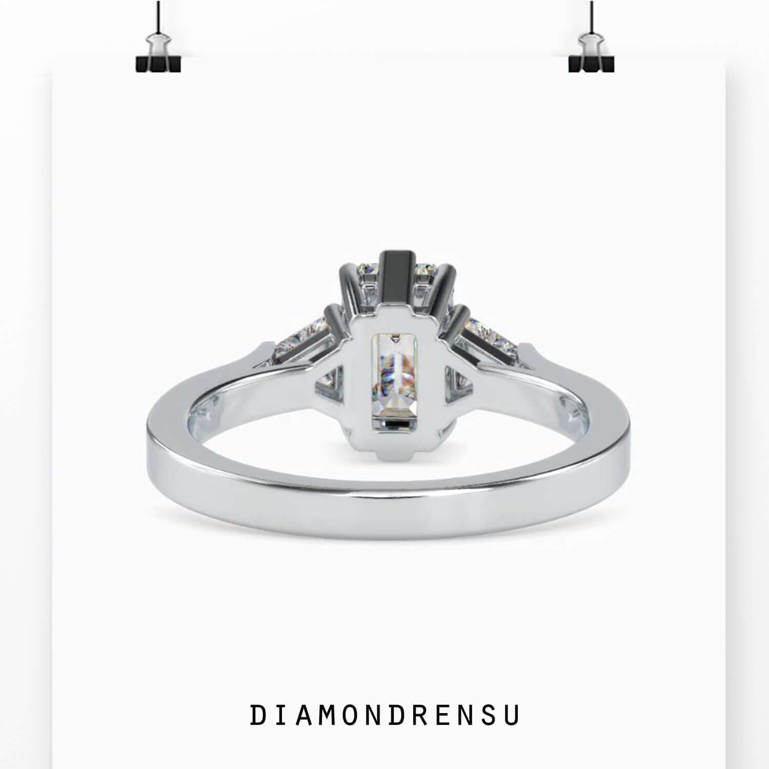 Rose gold engagement ring with emerald cut and side stones.