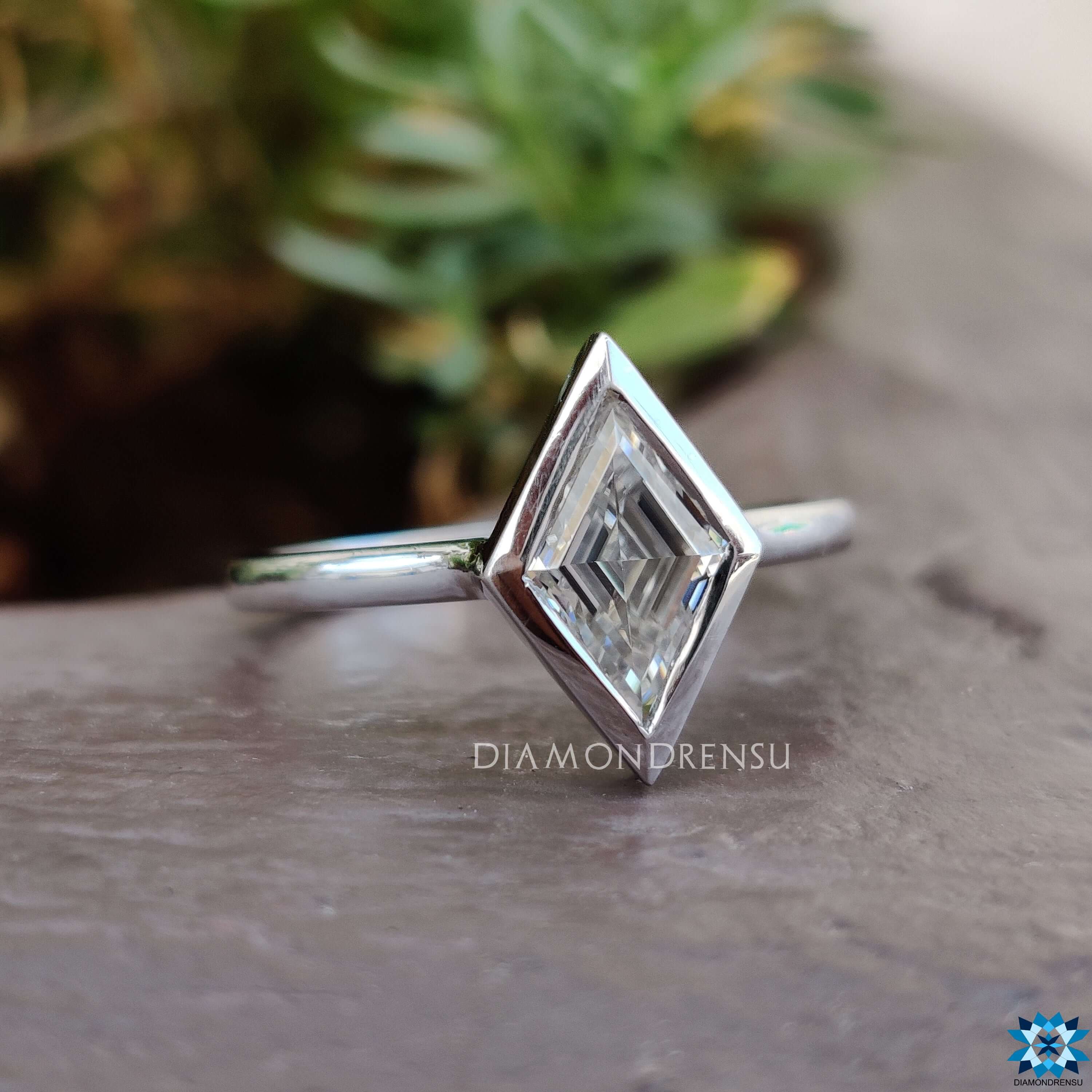 Custom engagement ring with white gold band and lozenge stone.