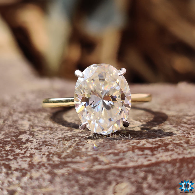 Hidden halo round cut moissanite ring in two-tone gold finish.