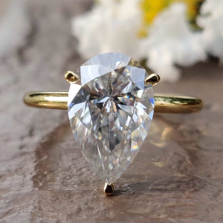 Pear cut moissanite solitaire ring in yellow gold.