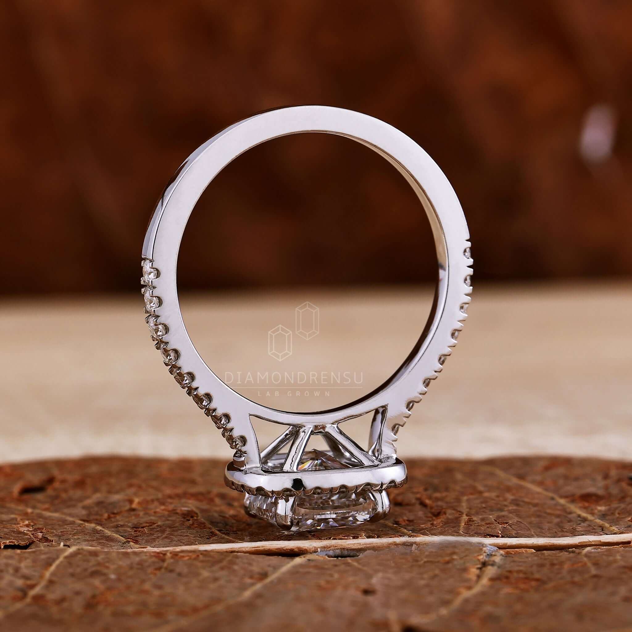 Cushion cut engagement ring with pave band detailing for elegance.