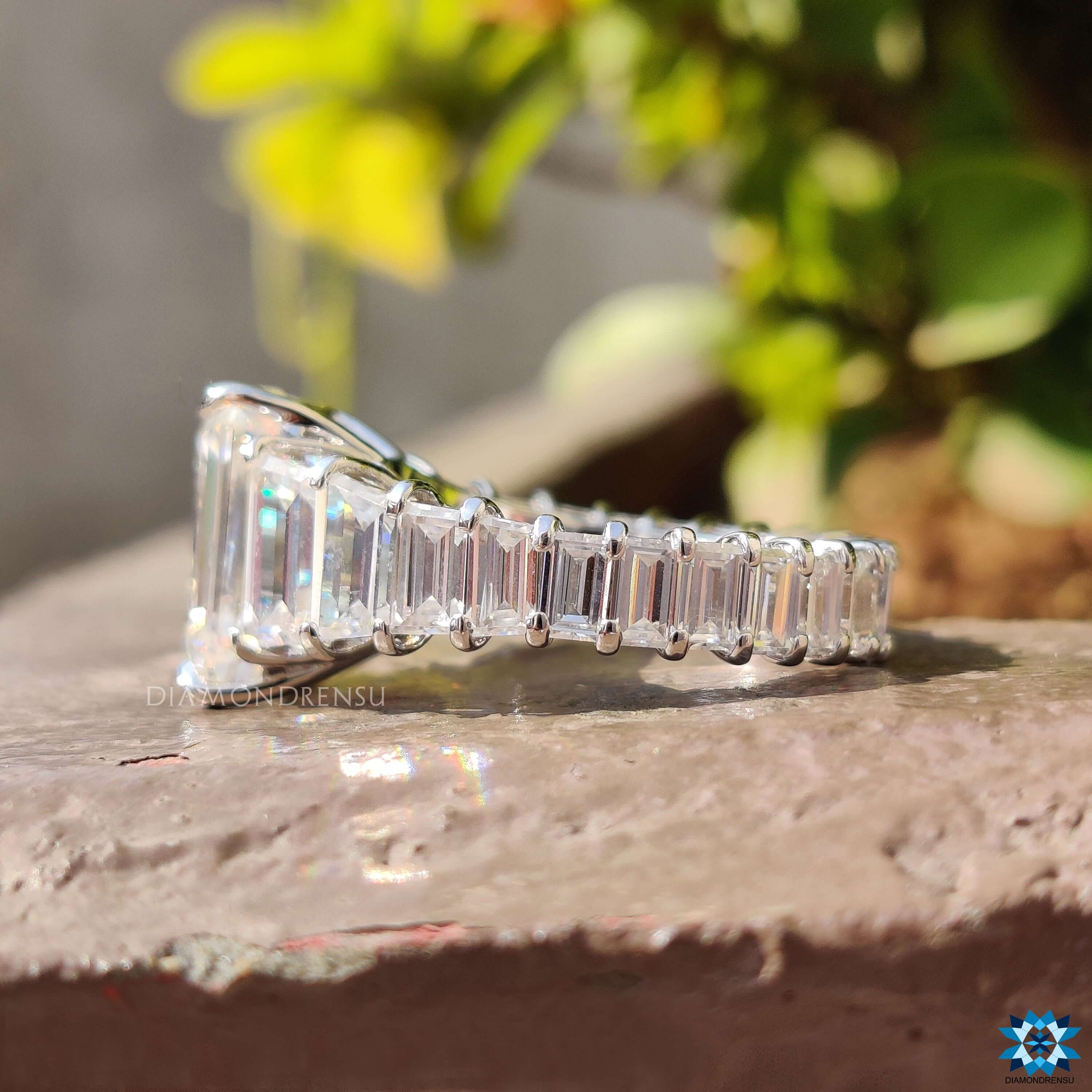 White gold ring with emerald cut moissanite and claw prong setting.