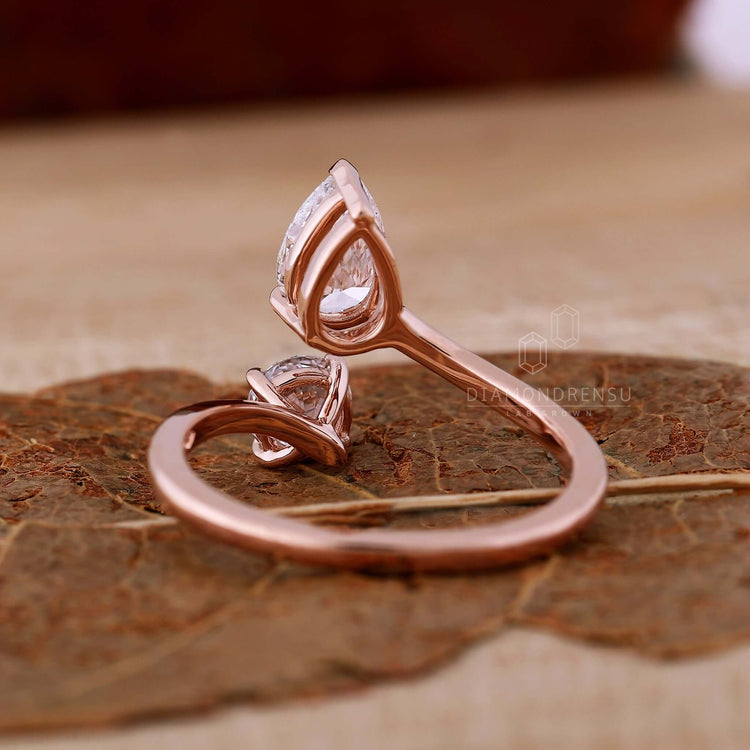 Two stone diamond ring featuring a pear cut diamond and round cut diamond in handmade jewelry design.