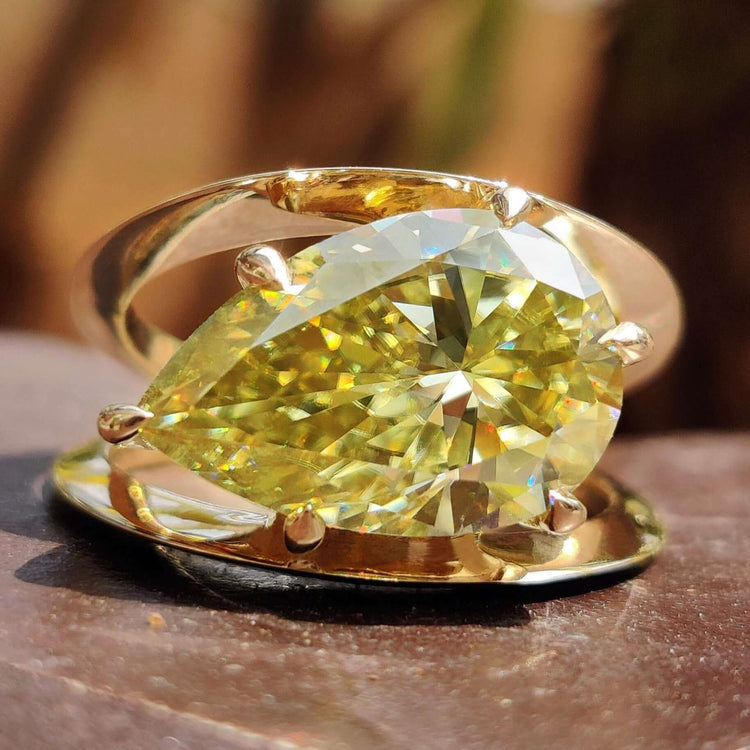 Canary yellow pear shape moissanite ring in yellow gold.