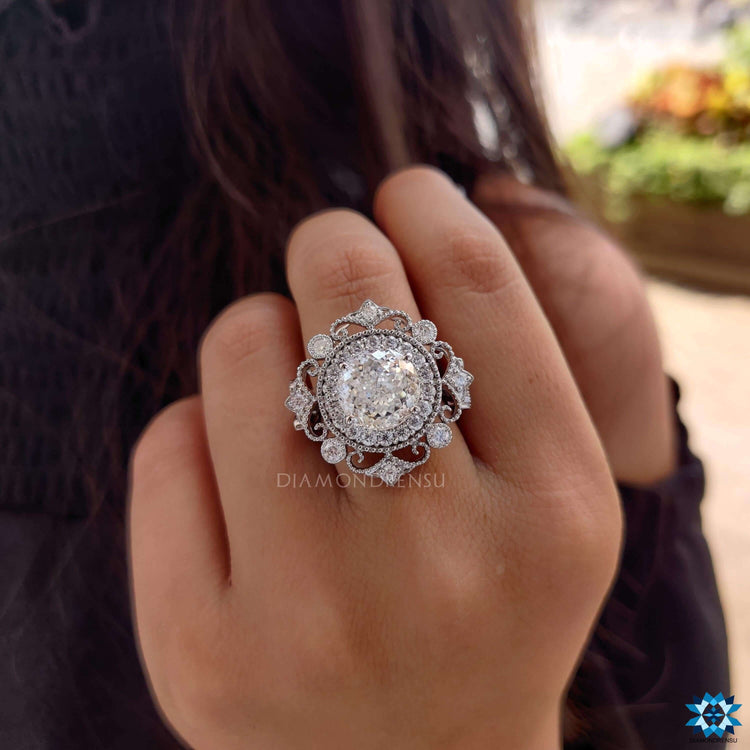 Moissanite halo ring in white gold with filigree detailing.