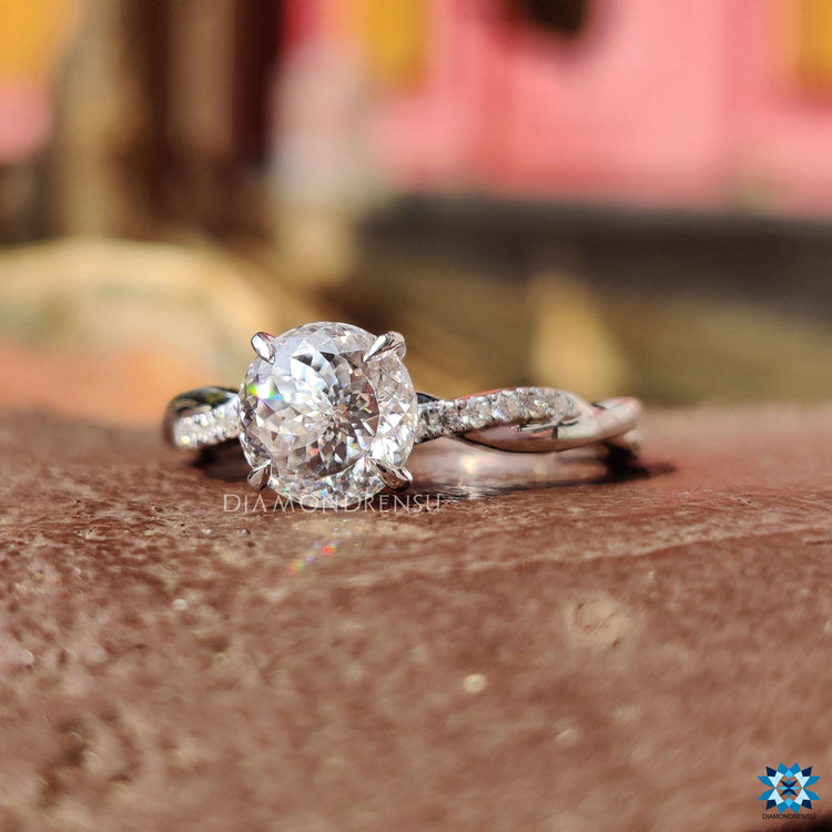 Handmade white gold ring with twisted band and round moissanite center.