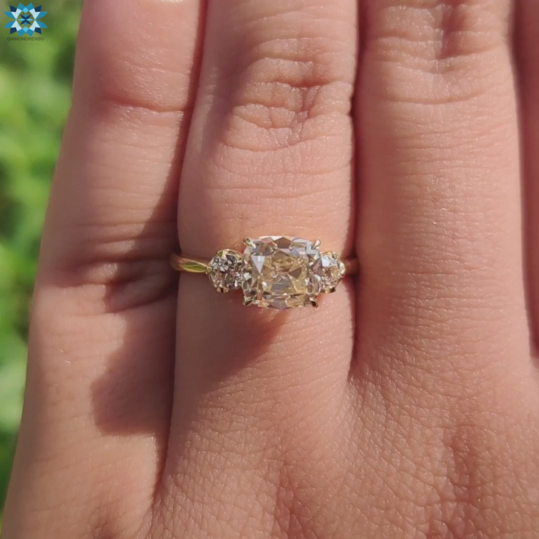 Cushion old mine cut center stone highlighted with vintage-inspired round side stones.