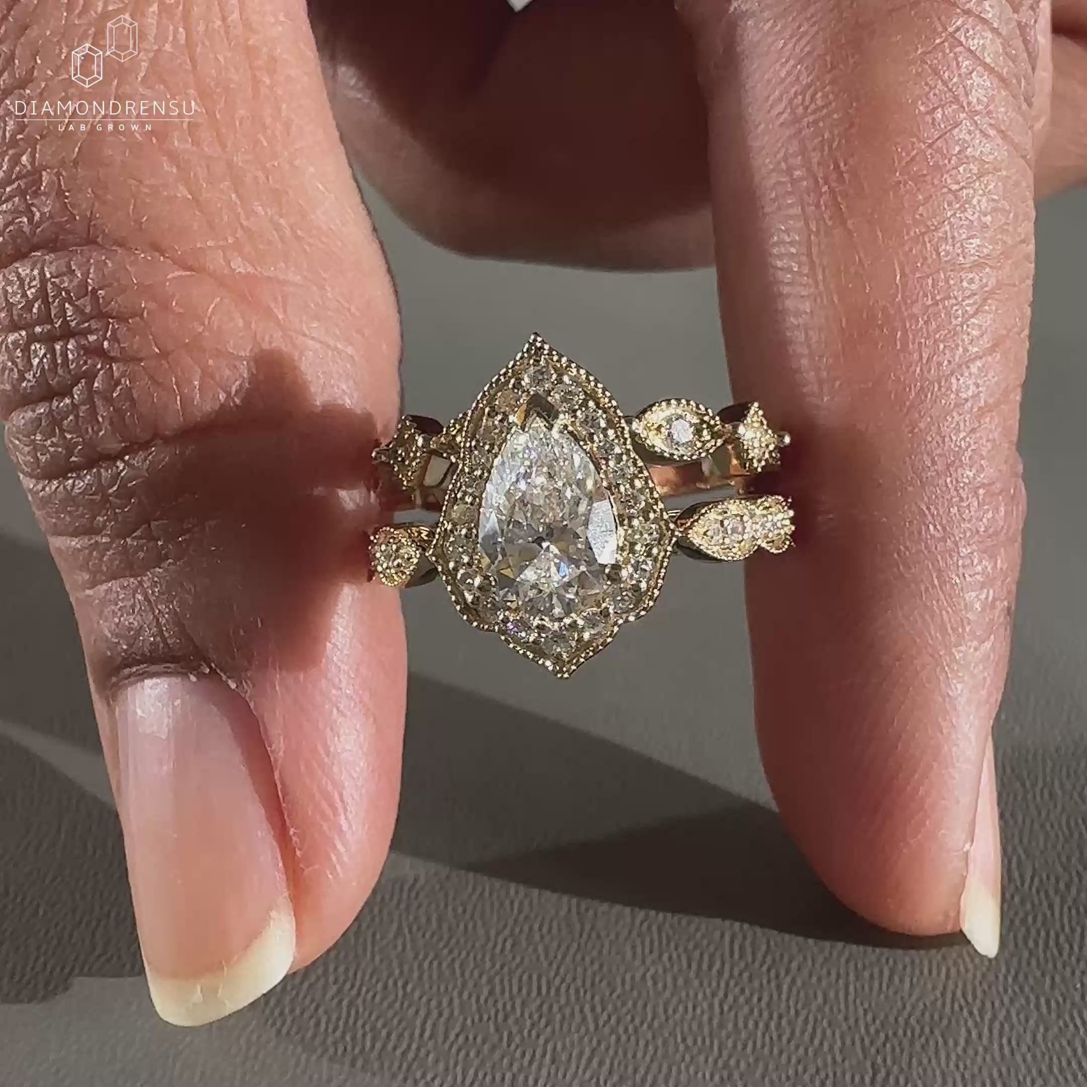 Pear diamond ring in cathedral setting ring with milgrain bridal set details.