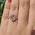 Cushion cut moissanite ring with hidden halo and claw prongs.