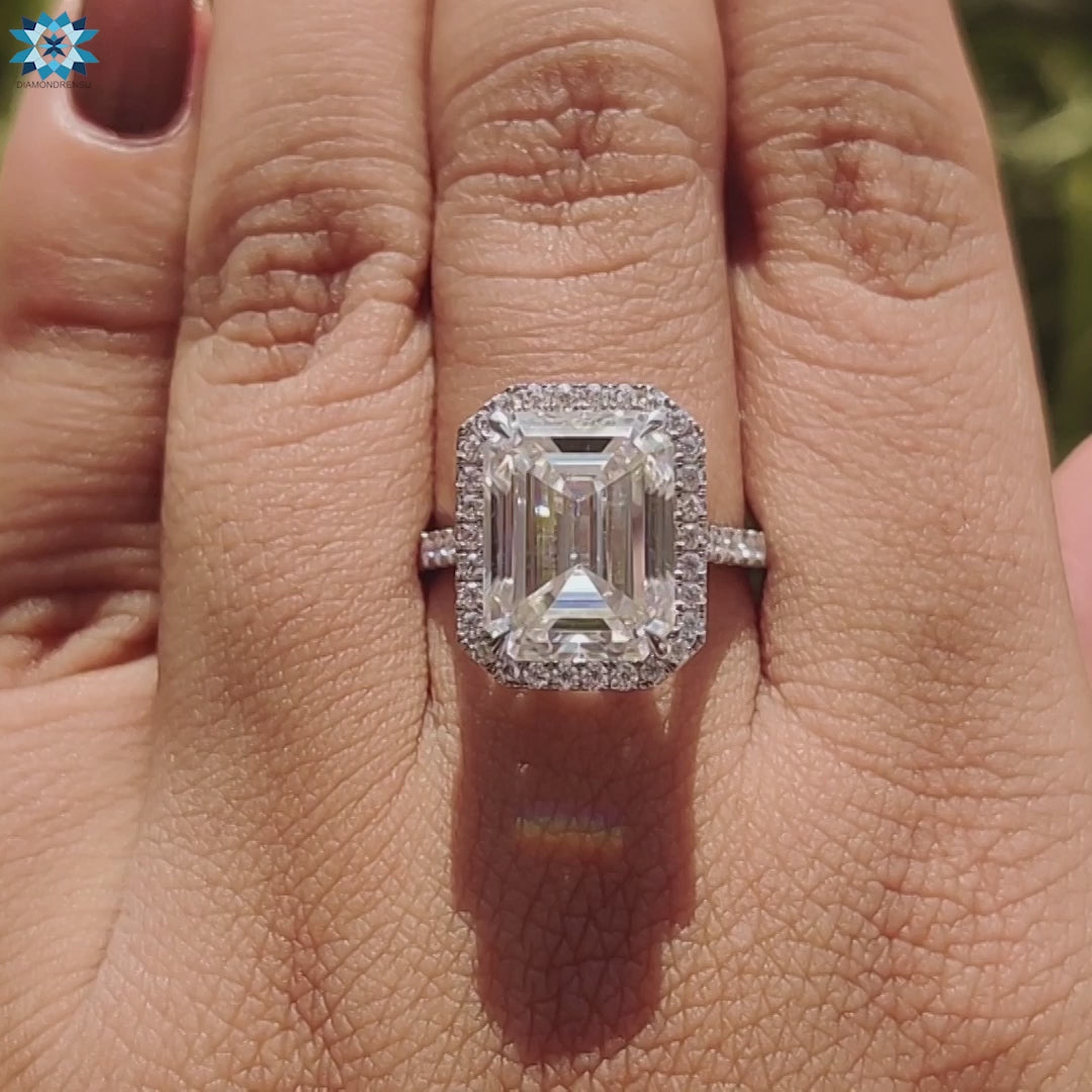 Elegant moissanite ring with emerald cut center and pavé band.