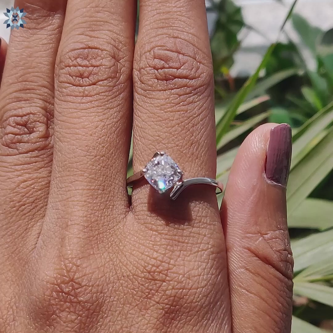 White gold ring with tension and prong set cushion moissanite.
