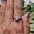 White gold ring with tension and prong set cushion moissanite.