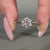 Round cut diamond ring featuring a tapered shank and hidden accents.