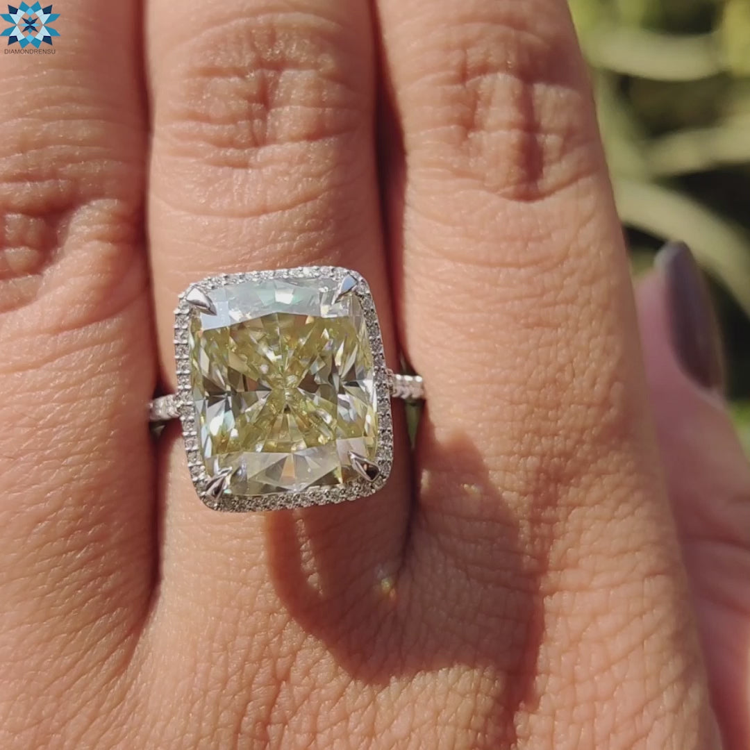 Yellow moissanite cushion ring with halo and pave band.
