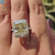Yellow moissanite cushion ring with halo and pave band.