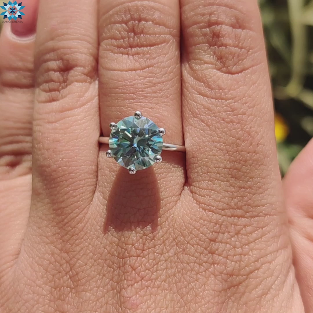 Diamondrensu UK ring featuring a round moissanite in solitaire mount.