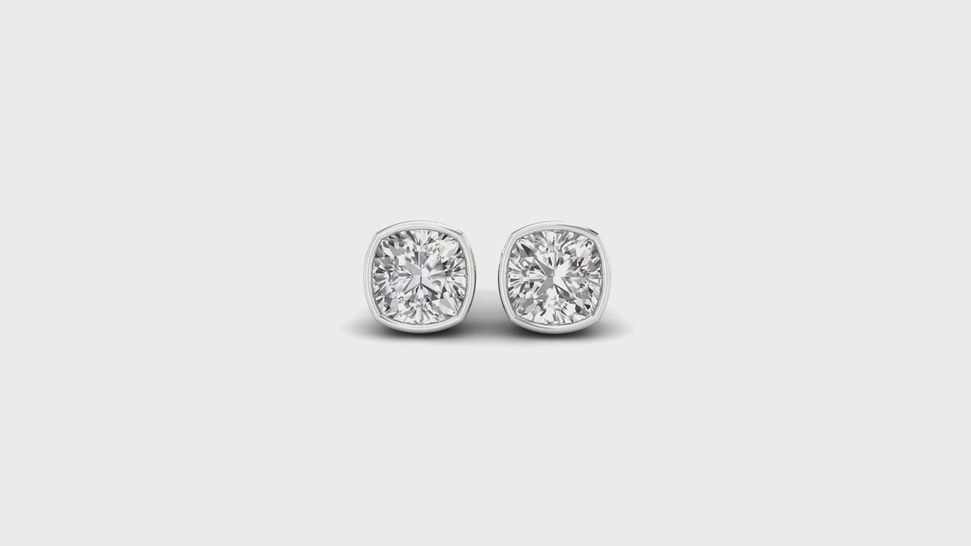 White gold bezel set earrings with cushion cut diamonds.
