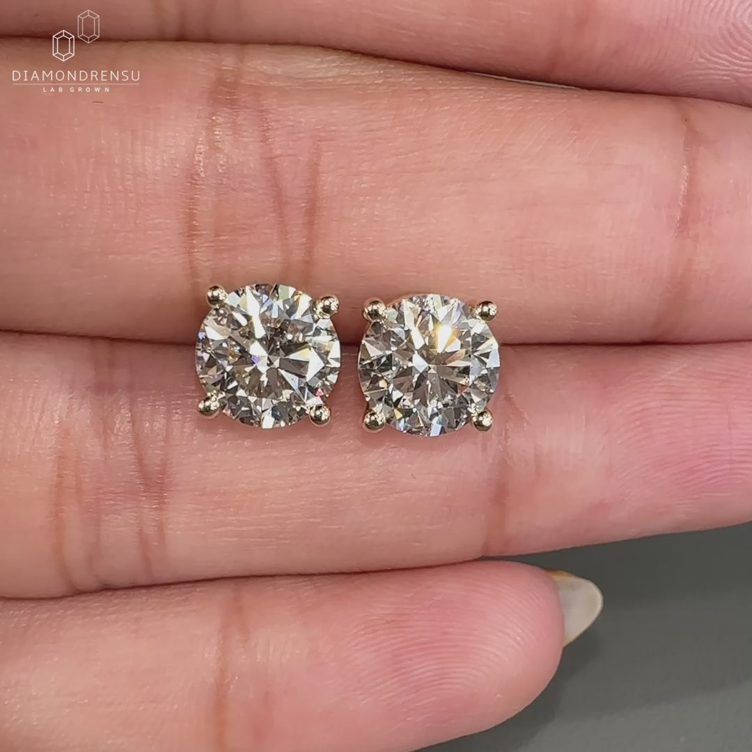 Round cut diamond earrings in yellow gold.