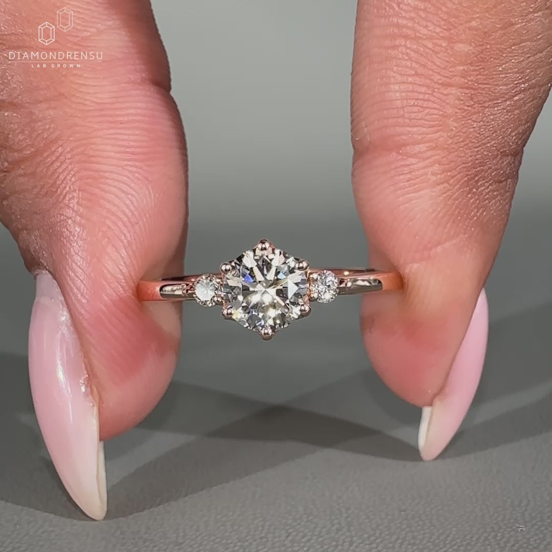 Three stone ring includes round diamond ring setting.