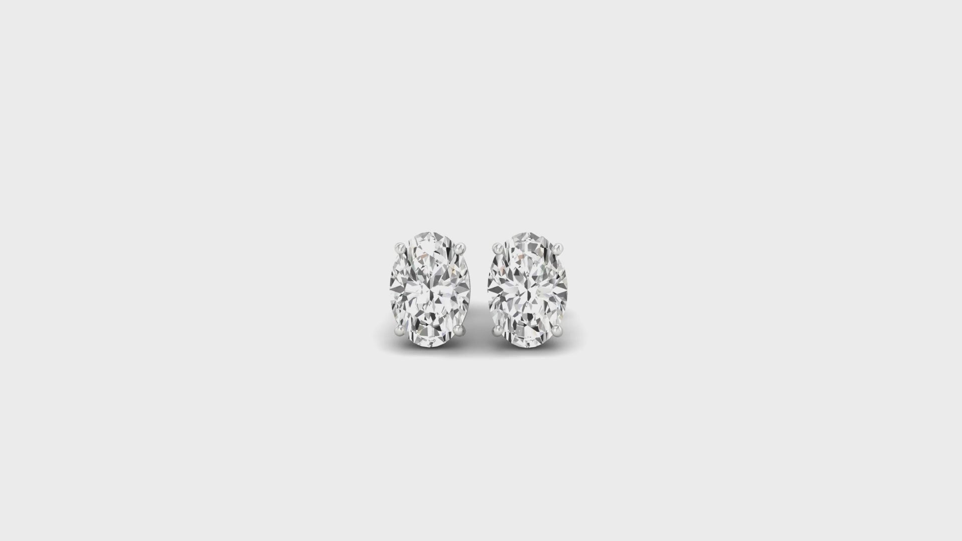 Oval cut diamond gold stud earrings in classic basket setting.
